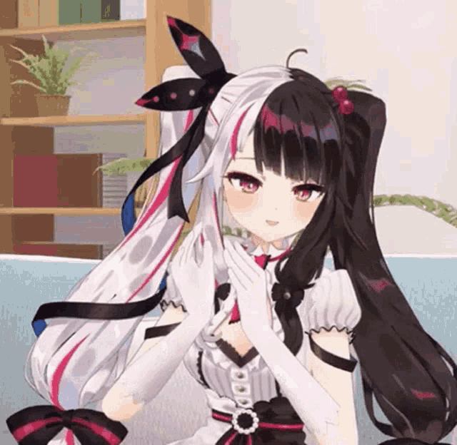 a black and white anime girl is sitting on a blue couch