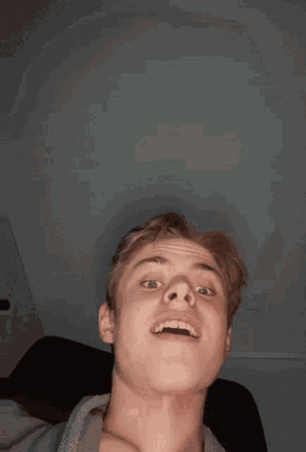 a young man is making a funny face with his mouth wide open