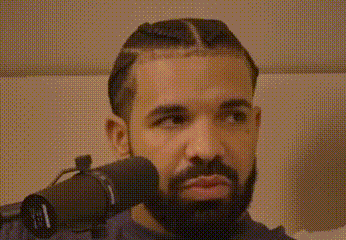 a man with a beard is wearing headphones and looking at the camera .