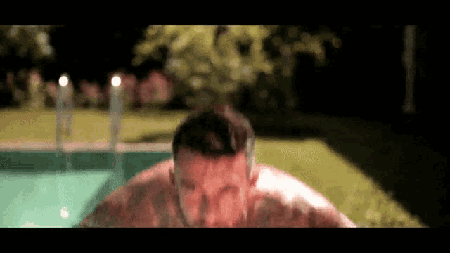 a man is jumping into a swimming pool with his head above the water