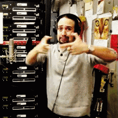 a man wearing headphones is making a funny face in front of a wall with a picture of a cat on it