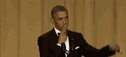 obama is wearing a tuxedo and bow tie and giving a speech .