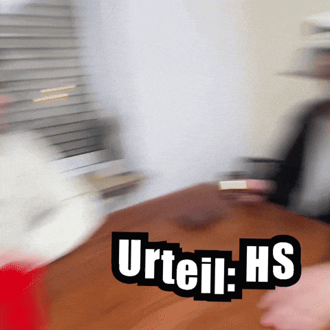 a blurred image of a person sitting at a table with urteil hs written on it