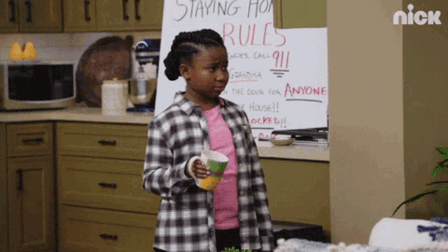 a girl in a plaid shirt stands in front of a sign that says staying home rules