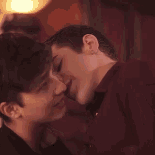 two young men are touching each other 's faces