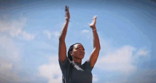 a woman is raising her arms in the air .