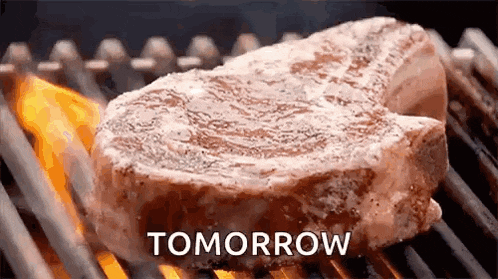 a steak is being cooked on a grill and the word tomorrow is above it .
