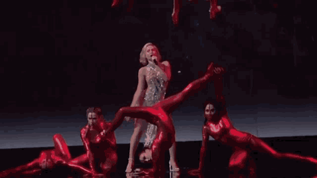 a group of people in red jumpsuits are performing on a stage