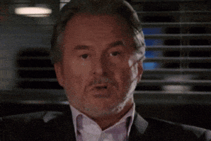 a man with a beard is wearing a suit and white shirt .