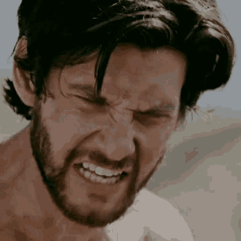 a man with a beard making a funny face with his eyes closed
