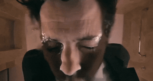 a close up of a man 's face with smoke coming out of his mouth .