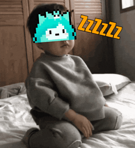 a baby is sitting on a bed with a pixelated image of a cat covering his face and the word zzzz written in orange
