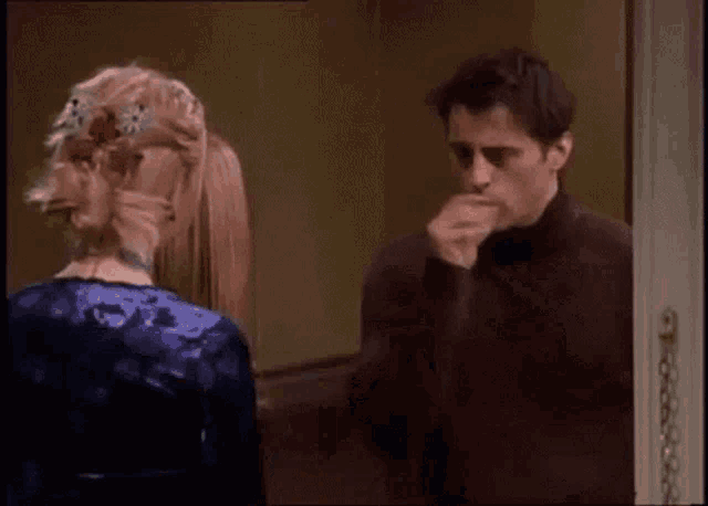 a man and a woman are standing next to each other in a doorway .