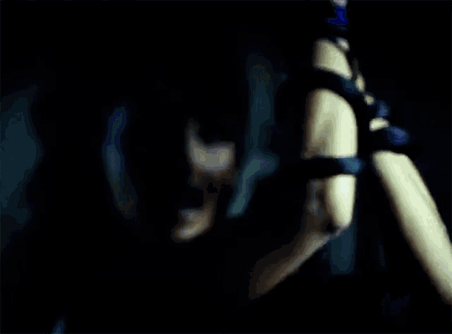 a woman is holding a sword in her hand in a dark room