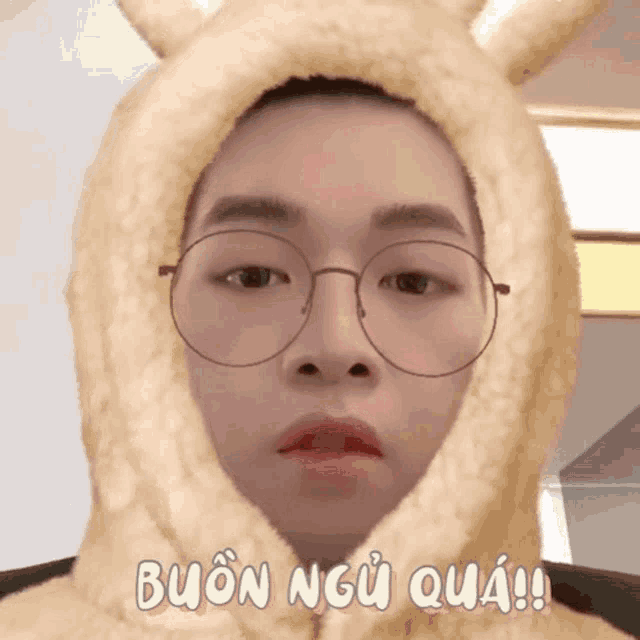 a man wearing glasses and a furry hood that says buon ngo qua