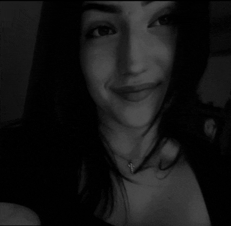 a black and white photo of a woman with a necklace around her neck