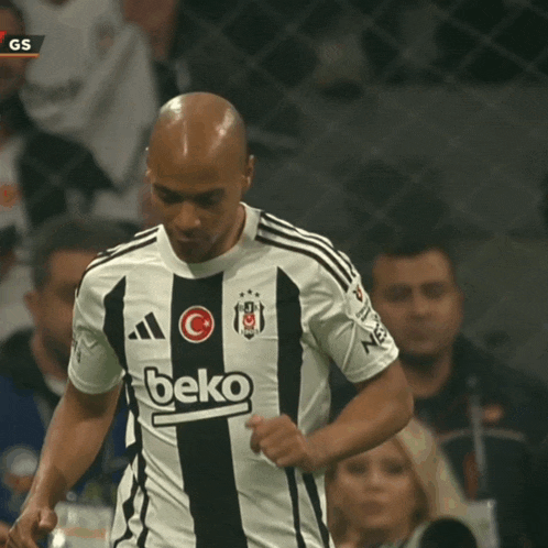 a soccer player wearing a black and white beko shirt
