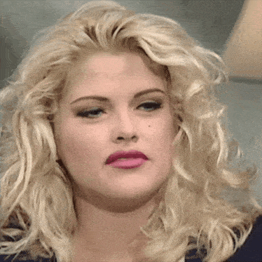 a close up of a woman 's face with blonde hair and pink lipstick