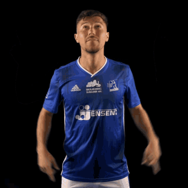 a man in a blue adidas shirt points up