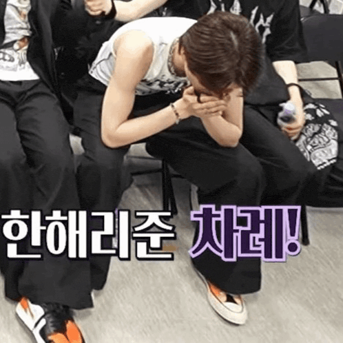 a group of people are sitting in chairs with korean writing on the floor .