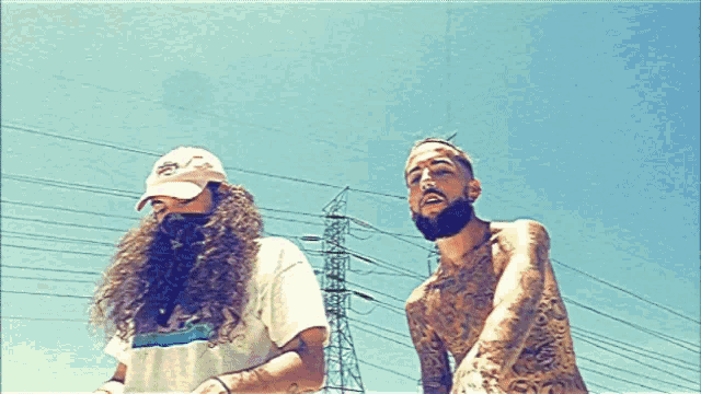 a man with a beard is standing next to a man with long hair