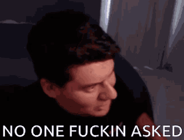 a man is making a funny face with the words no one fuckin asked behind him .