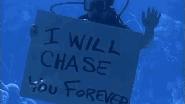 a scuba diver is holding a sign that says `` i will chase you forever '' in the ocean .