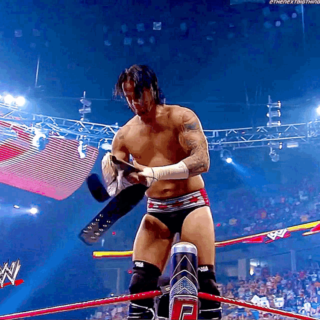 a shirtless wrestler in a wrestling ring with the number 2 on the ring post