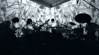 a black and white photo of a band playing in front of a screen that says ' svf ' on it