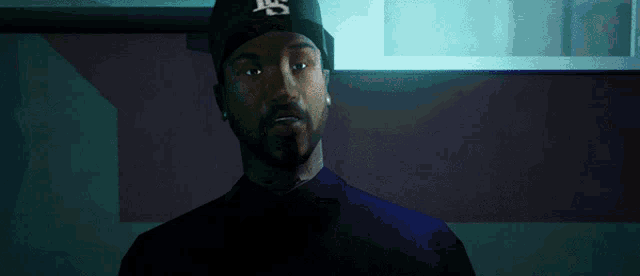 a man with a beard wearing a hat with the letter ls on it