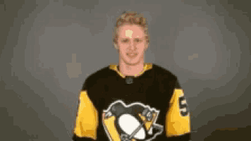 a hockey player is wearing a black and yellow jersey with the number 5 on it