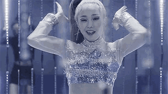 a black and white photo of a woman in a crop top dancing .