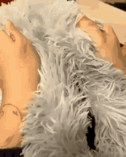 a close up of a person laying on a fluffy pillow
