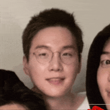 a close up of a man 's face with glasses and a red heart in the background