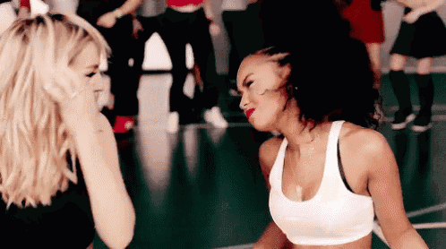 two women are dancing together on a dance floor .