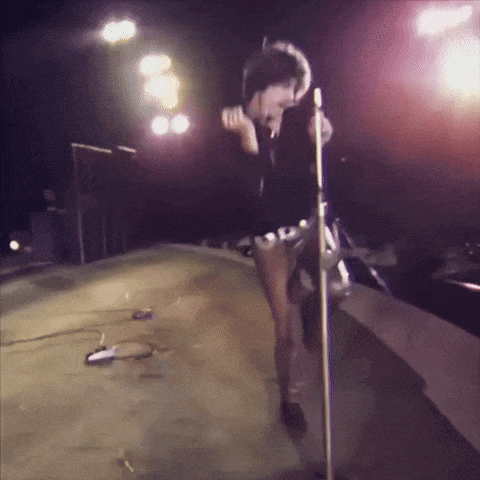 a woman singing into a microphone while wearing shorts that say ' sd '