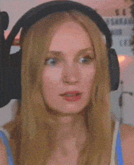 a woman wearing headphones is making a funny face and says what