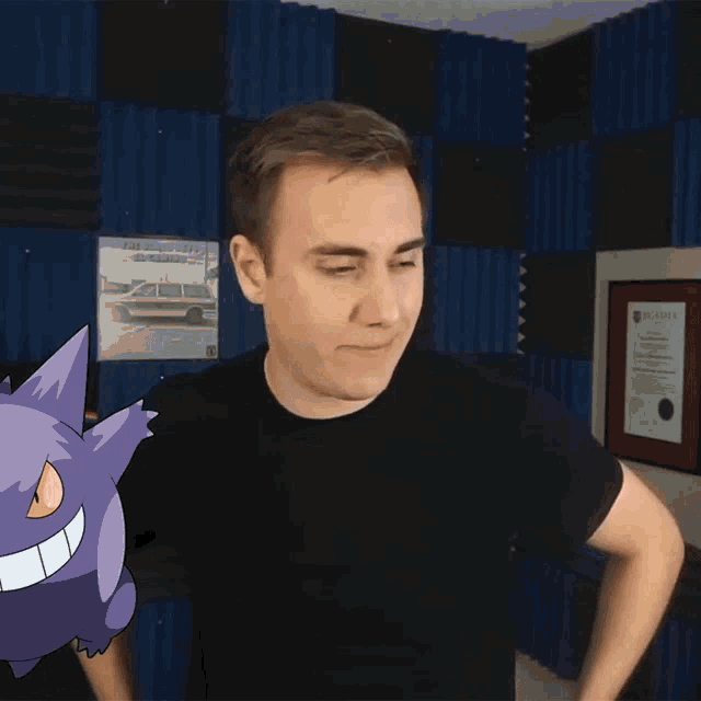 a man in a black shirt is standing next to a purple cartoon pokemon