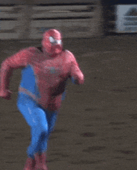 a person in a spiderman costume is laying on the ground in front of a sign that says coors light