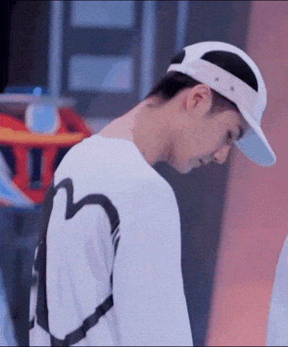 a close up of a person wearing a hat and a white shirt .