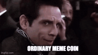 a man is sitting in a crowd of people and making a funny face while holding his hand to his face .