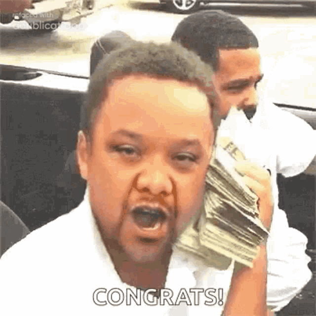 a man is holding a large stack of money in his hand .