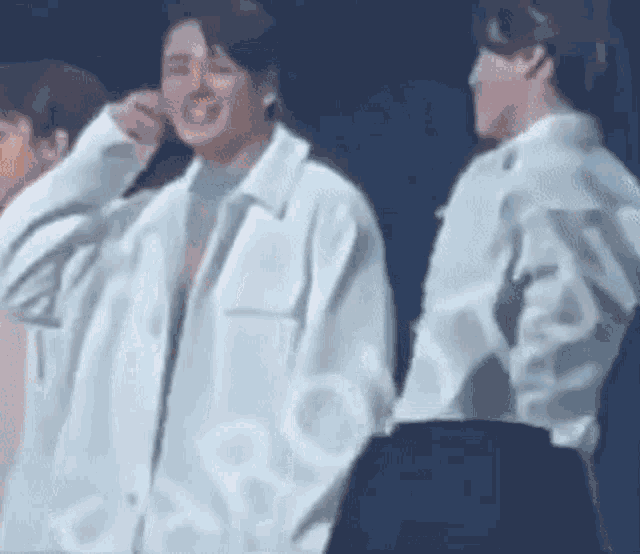 a group of people are standing next to each other on a stage and one of them is smiling .
