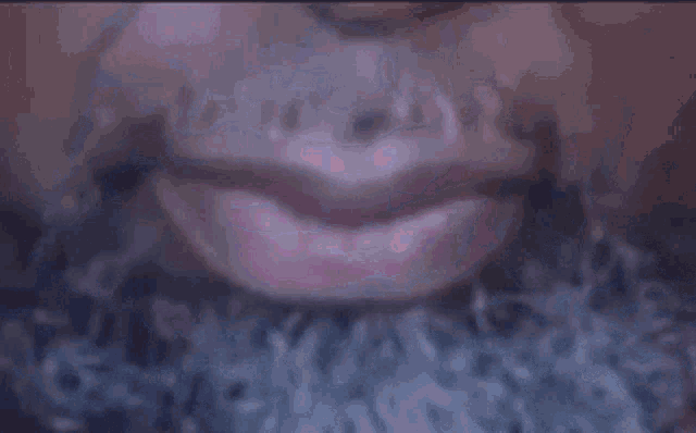a close up of a woman 's mouth with a beard and a purple background .