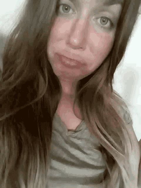 a woman with long hair making a sad face