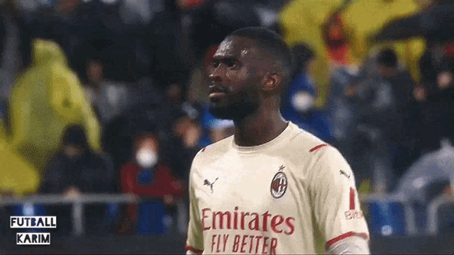 a soccer player wearing a jersey that says emirates fly better on it