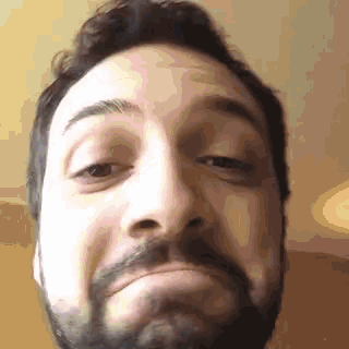 a close up of a man with a beard making a funny face .