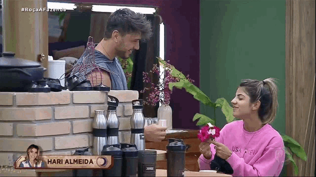 a man and a woman are sitting at a table with a sign that says hari almeida on it