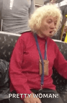 a woman with blonde hair is sitting on a bus smoking a cigarette and says `` pretty woman '' .