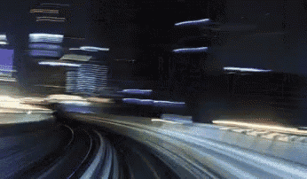 a blurry picture of a train going down a track at night